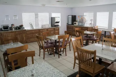 a restaurant with tables and chairs and a kitchen at California Inn Barstow in Barstow