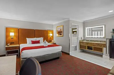 a hotel room with a bed and a bathroom at Del Sol Inn Anaheim in Anaheim