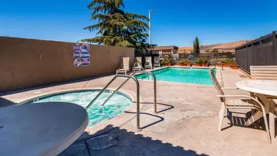 a swimming pool with a table and chairs next to it at SureStay Hotel by Best Western Tehachapi in Tehachapi