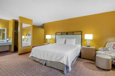 a hotel room with a large bed and a chair at SureStay Hotel by Best Western Camarillo in Camarillo