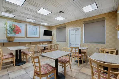 a dining room with tables and chairs and a tv at SureStay Hotel by Best Western Camarillo in Camarillo