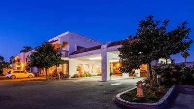 a building with a car parked in a parking lot at SureStay Hotel by Best Western Camarillo in Camarillo