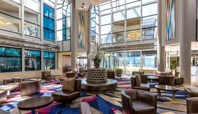 a lobby with chairs and tables and windows at Hilton Los Angeles-Universal City in Los Angeles