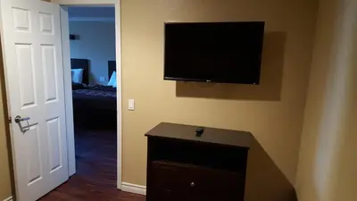 a room with a flat screen tv on the wall at Anaheim Astoria Inn & Suites in Anaheim