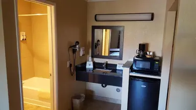 a bathroom with a sink and a microwave at Anaheim Astoria Inn & Suites in Anaheim