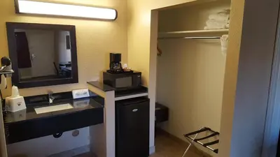 a bathroom with a sink and a microwave at Anaheim Astoria Inn & Suites in Anaheim