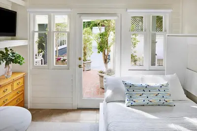 a living room with a couch and a sliding glass door at Channel Road Inn, A Four Sisters Inn in Los Angeles