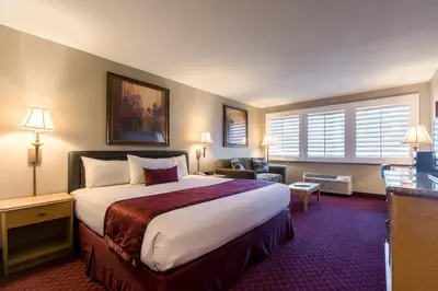 a hotel room with a large bed and a couch at Grand Vista Hotel in Simi Valley