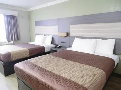 a hotel room with two beds and a window at Americas Best Value Inn-Rialto in Rialto