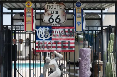 a statue in front of a gate with a sign at Wigwam Motel in San Bernardino
