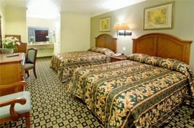 a hotel room with two beds and a desk at Americas Best Value Inn San Bernardino in San Bernardino
