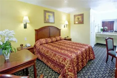 a hotel room with a bed and a table at Americas Best Value Inn San Bernardino in San Bernardino