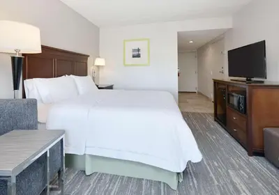 a hotel room with a bed and a flat screen tv at Hampton Inn Los Angeles/Carson in Carson