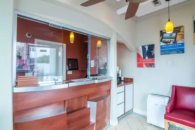 a kitchen with a counter and a red chair at Motel 6-Norwalk, CA in Norwalk