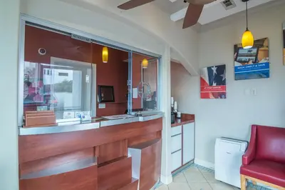 a bathroom with a counter and a red chair at Motel 6-Norwalk, CA in Norwalk