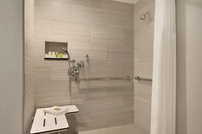 a bathroom with a shower with a sink at Hilton Checkers Los Angeles in Los Angeles