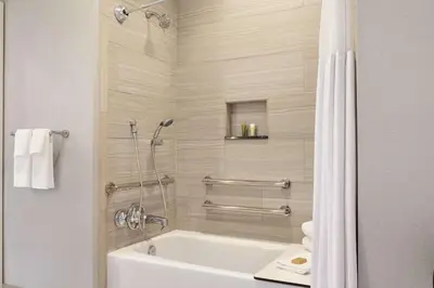 a bathroom with a white tub and a shower at Hilton Checkers Los Angeles in Los Angeles