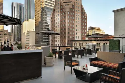 a rooftop patio with tables and chairs on a building at Hilton Checkers Los Angeles in Los Angeles