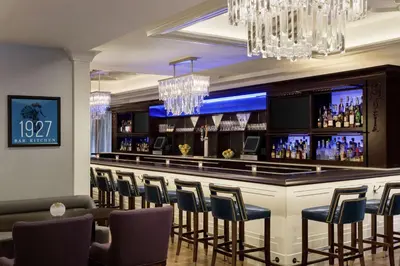 a bar in a hotel with chairs and lights at Hilton Checkers Los Angeles in Los Angeles