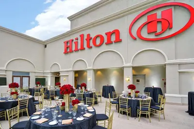 a ballroom with tables and chairs in front of a fusion at Hilton Checkers Los Angeles in Los Angeles
