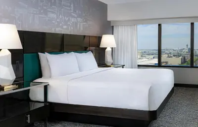 a bedroom with a large white bed and a window at Hilton Los Angeles Airport in Los Angeles