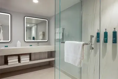 a bathroom with a shower and a sink and a mirror at Hilton Los Angeles Airport in Los Angeles