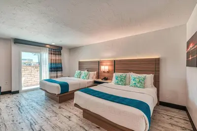 a hotel room with two beds and a window at Casa Via Mar Inn, an Ascend Collection Hotel in Port Hueneme
