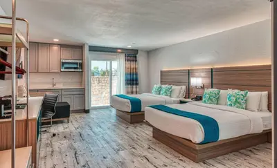 a hotel room with two beds and a kitchen at Casa Via Mar Inn, an Ascend Collection Hotel in Port Hueneme