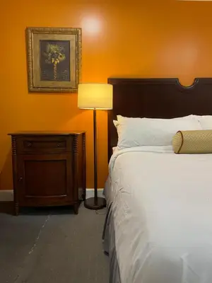 a bedroom with a bed and a lamp next to a table at Howard Johnson by Wyndham Ridgecrest, CA in Ridgecrest