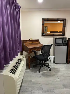 a desk and a chair in a room with a mirror at Howard Johnson by Wyndham Ridgecrest, CA in Ridgecrest