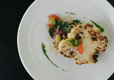 a plate of food with vegetables on a table at Ojai Valley Inn in Ojai
