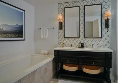 a bathroom with a tub and a sink and two mirrors at Ojai Valley Inn in Ojai