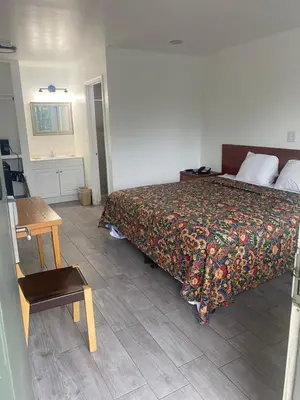a bedroom with a bed and a wooden table at Americas Best Value Inn Thousand Oaks in Thousand Oaks