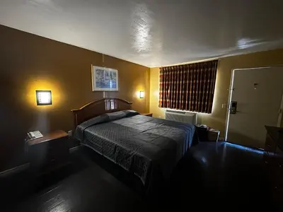 a hotel room with a bed and a window at Sunpark Inn & Suites in San Bernardino