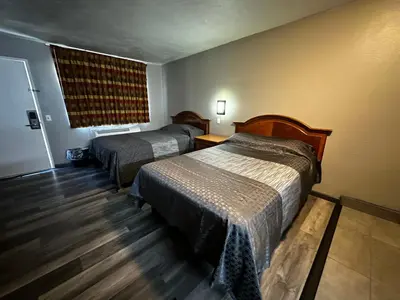 a hotel room with two beds and a window at Sunpark Inn & Suites in San Bernardino