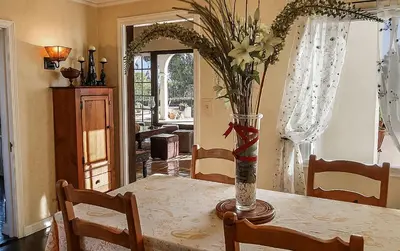 a dining room table with a vase of flowers on it at The Patrician Hollywood Universal in Pasadena