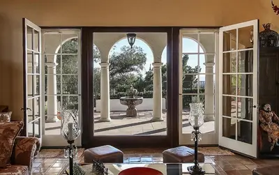 an open door to a patio with a fountain outside at The Patrician Hollywood Universal in Pasadena