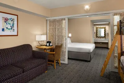a hotel room with a bed and a couch at Anaheim Portofino Inn & Suites in Anaheim