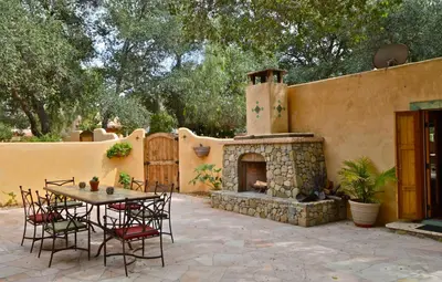 a patio with a table and a fireplace at Blue Iguana Inn in Ojai