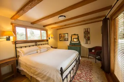 a bedroom with a bed and a chair and a window at Blue Iguana Inn in Ojai