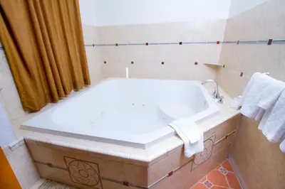 a bathroom with a white sink and a tub at Mission Bell Motel in Ventura