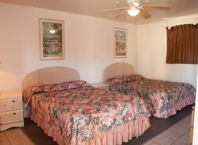 a hotel room with two beds and a ceiling fan at Mission Bell Motel in Ventura