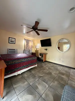 a bedroom with a bed and a ceiling fan at Mission Bell Motel in Ventura