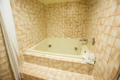 a bath tub in a tiled bathroom at Anaheim Carriage Inn in Anaheim