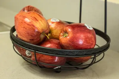 a basket of apples sitting on a counter at Anaheim Carriage Inn in Anaheim