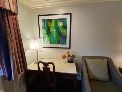a desk with a chair and a table with a lamp at Best Inn Rosemead in Rosemead