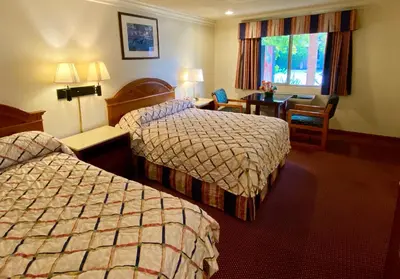 a hotel room with two beds and a desk at Best Inn Rosemead in Rosemead
