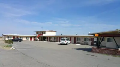 a car parked in a parking lot in front of a motel at Budget Inn Mojave in Mojave