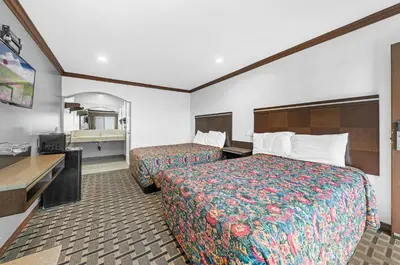 a hotel room with two beds and a television at Starlight Inn South El Monte in South El Monte