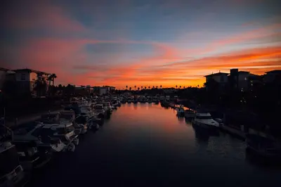 a group of boats docked in a river at sunset at Hampton Inn Channel Islands Harbor in Oxnard